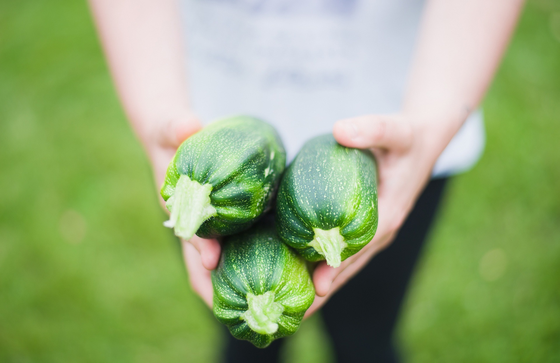 Vrouw houdt drie courgettes vast